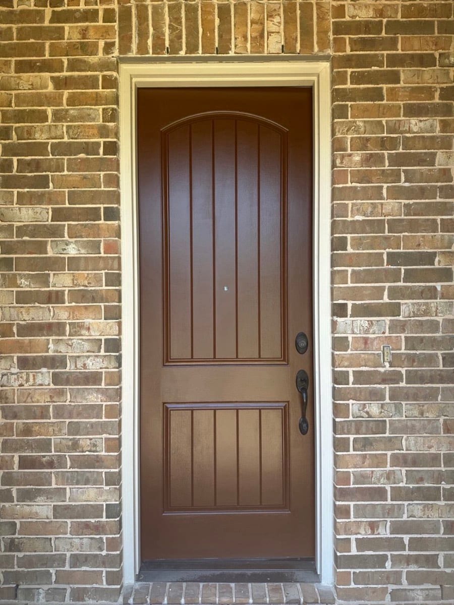 Refinished front door in a brick entryway