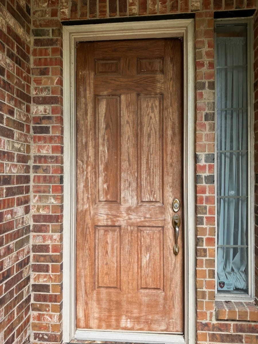 Oak front door with a sun-bleached, worn finish before refinishing