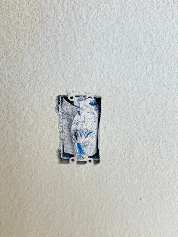 The hole patched and fresh texture sprayed to match the wall
