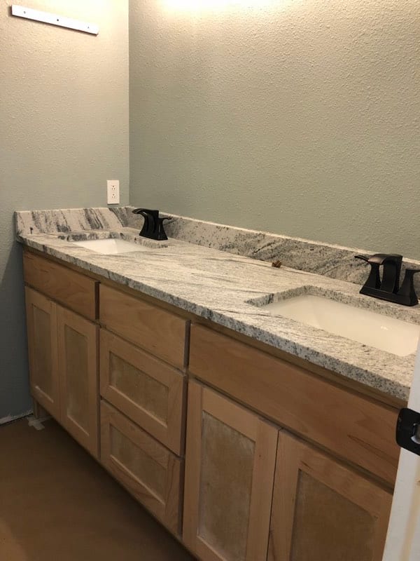 Bathroom vanity with bare unfinished wood cabinets before painting