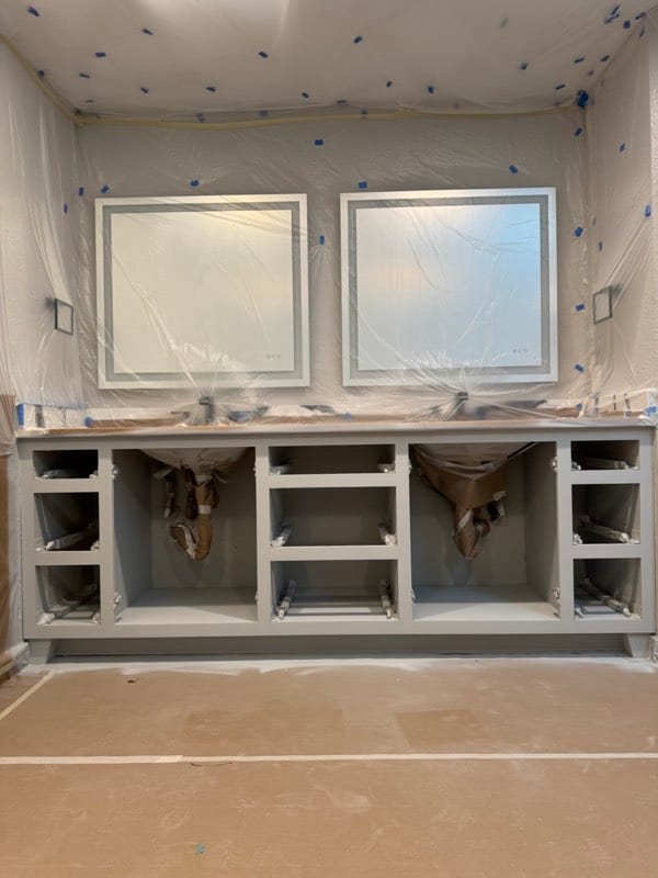 The same vanity primed, doors removed and the room masked off
